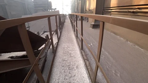Worker walking on a polluted graphite-covered roof of old steel plant. Video stock 106450475