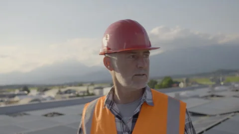 Worker walking on rooftop solar panel array front view tracking shot Stock Footage 278468806