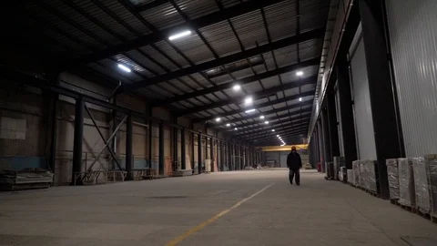 The worker is walking through the empty workshop Stock Footage 105228544