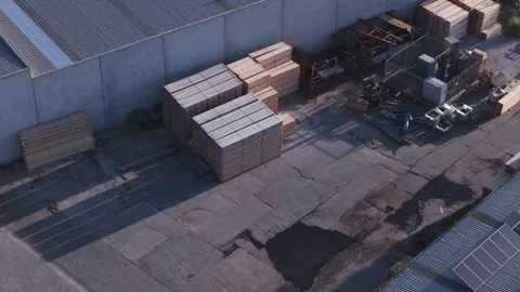 Worker walking through an industrial yard with stacks of lumber Stock Footage 346394514