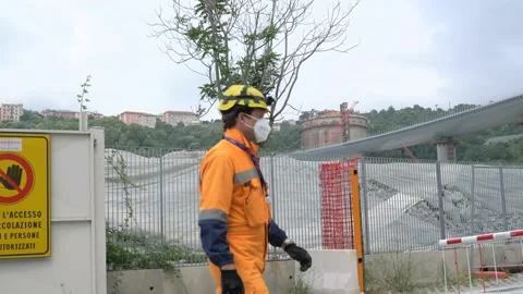 Worker  walking towards the new morandi bridge site Stock Footage 133793289