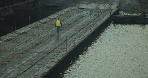 A worker walks on a pontoon bridge Stock Footage 131340495