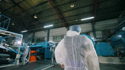 The worker walks through the factory. a worker in uniform walks through a Stock-Footage 220055444