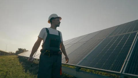 A worker walks through a solar panel station, analyzing their performance. Stock Footage 264070471