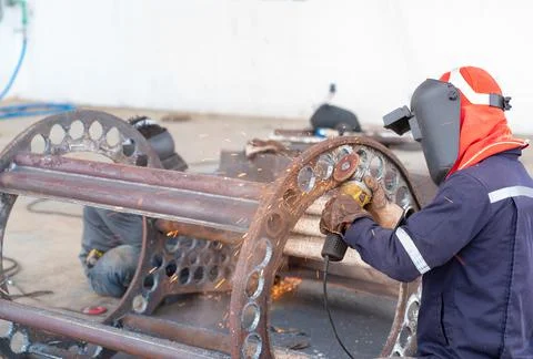 Worker ware gloves use electric grinding wheel stone. Stock Photos