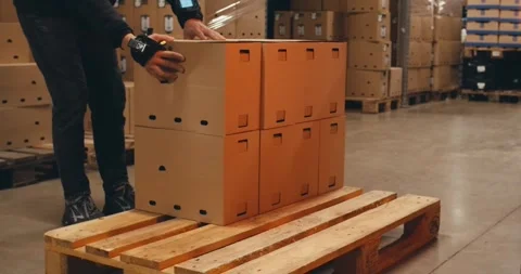 Worker in warehouse carries pallets of boxes stacks goods packs. Stock Footage 312067025