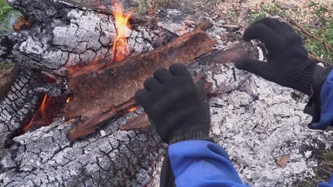 Worker warms his hands in gloves around the fire Stock Footage 103350428