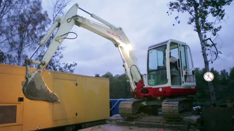 Worker washes dirty loader from the hose at the evening Stockbeeldmateriaal 36168678