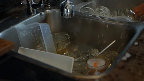 Worker washes dishes in a restaurant kitchen Stock Footage 121781974