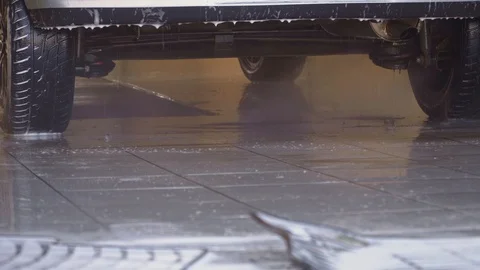 A worker washes mats for a car under water pressure with a foam Stock Footage 105966920