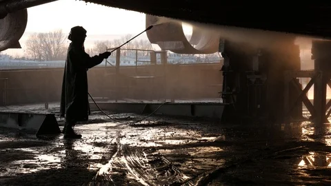 The worker washes the seashell off the barge with water jet Stock Footage 87545377