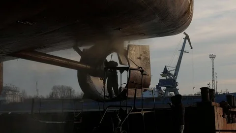 The worker washes the ship's hull, in dry dock Stock Footage 87505896