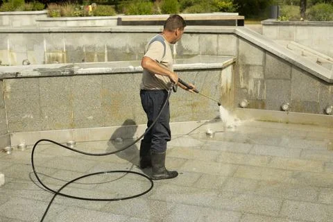 The worker washes the surface from rust. Stock Photos