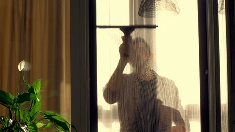 A worker washes a window at home, uses special tools Stock Footage 129991314