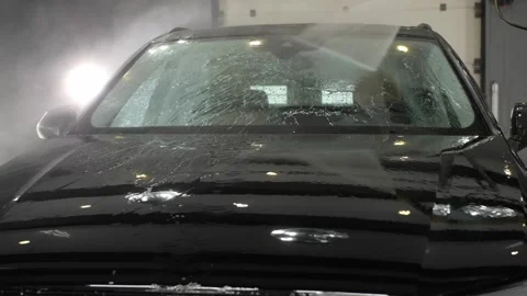 Worker washes the windshield with a high pressure washer at a car wash. Stock-Footage 247239216