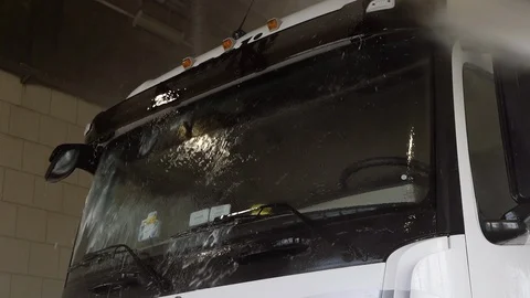 Worker washes windshield of truck with spray of water Stock Footage 126095979