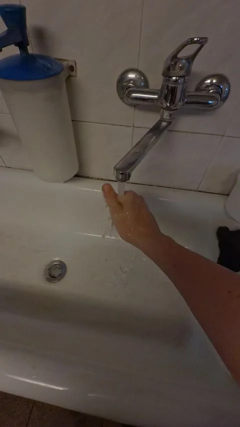 Worker washing hands under a faucet in a utility sink Stock Footage 339669759