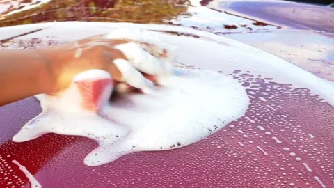 Worker washing red car with sponge on a car wash. Car Wash Business Banner. Stock Footage 163944724