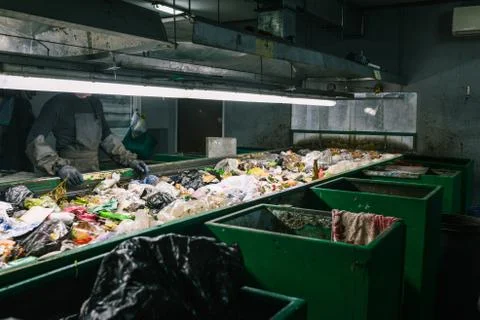 Worker waste sorting plant. Sort garbage. Waste container. Man in gloves and Stock Photos