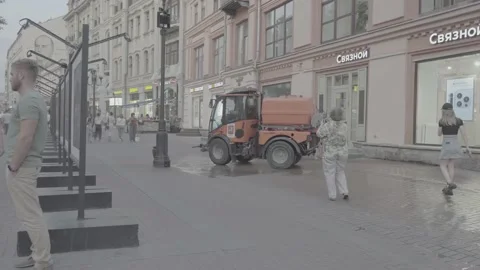 A worker on a watering machine washes the street. S-Log Stock Footage 205190838