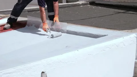 Worker waterproofing a flat roof with roller Stock Footage 336203322