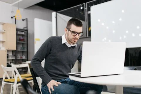 Worker wearing glasses using laptop on office desk Stock Photos