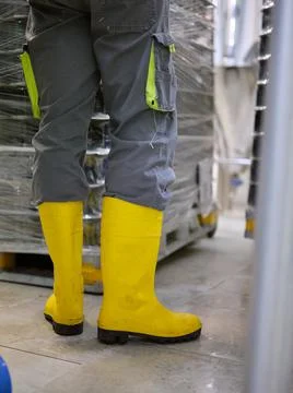 Worker wearing protective boots in a craft beer canning factory Stock Photos