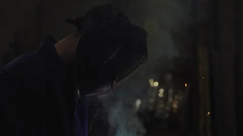 Worker wearing a protective face mask while welding Stock Footage 266848671