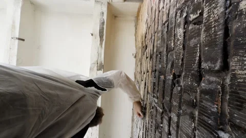 Worker wearing protective suit washes moldy brick wall in building 스톡 동영상 323865173