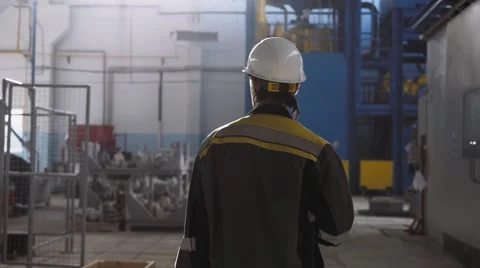 Worker wearing safety hat and uniform in a modern factory Stock Footage