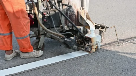 Worker wearing uniform is making the white line on road with painting machine 動画素材 163982212