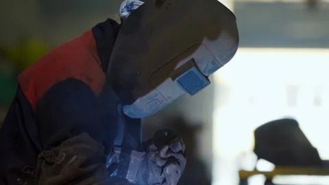 Worker is wearing welding shield while fusing multiple parts at metallurgy plant 스톡 동영상 197344500