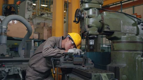 Worker wears hard hat, concentrates on machine Stock Footage 346268948