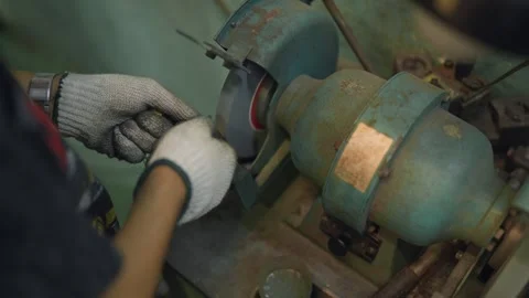 Worker wears white gloves, grinding metal piece 動画素材 346268651