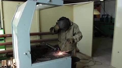 Worker-welder does his job, processes metal and works in a protective suit, Stock Footage 124576544