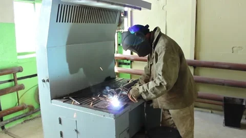 Worker-welder does his job, processes metal and works in a protective suit, Stock Footage 124576561