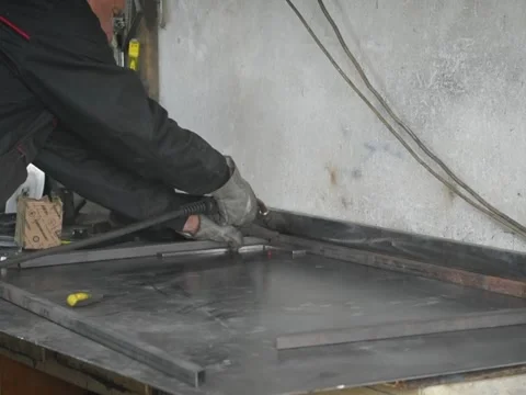 A Worker, welder in work clothes, construction gloves and a welding mask Stock Footage 255132304