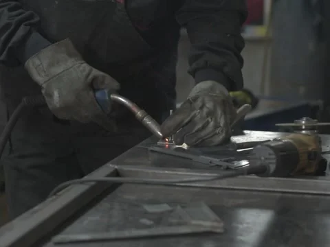 A Worker, welder in work clothes, construction gloves and a welding mask Stock Footage 255133975