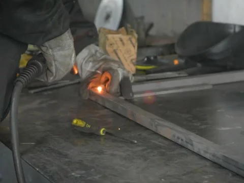 A Worker, welder in work clothes, construction gloves and a welding mask Stock Footage 255138878