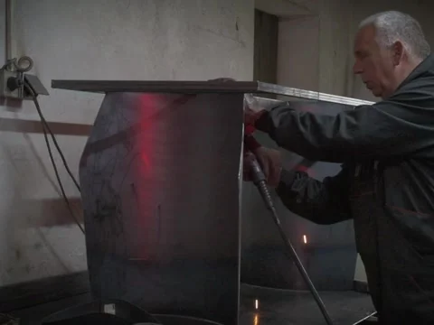 A Worker, welder in work clothes, construction gloves and a welding mask Stock Footage 255151251