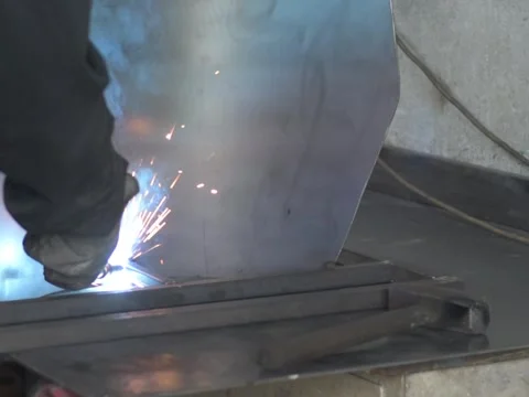 A Worker, welder in work clothes, construction gloves and a welding mask Stock Footage 255151275