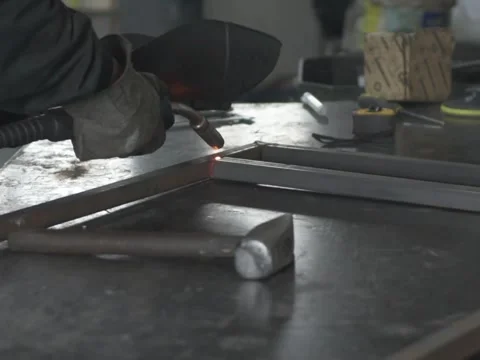 A Worker, welder in work clothes, construction gloves and a welding mask Stock Footage 255151281