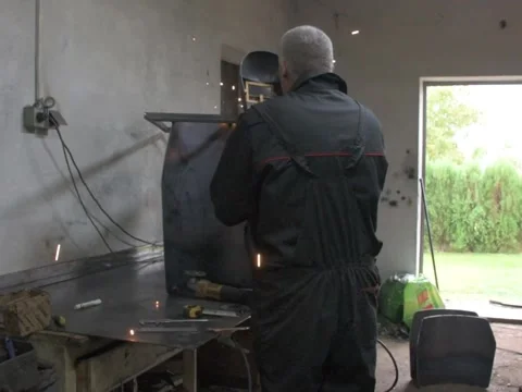 A Worker, welder in work clothes, construction gloves and a welding mask Stock Footage 255151429