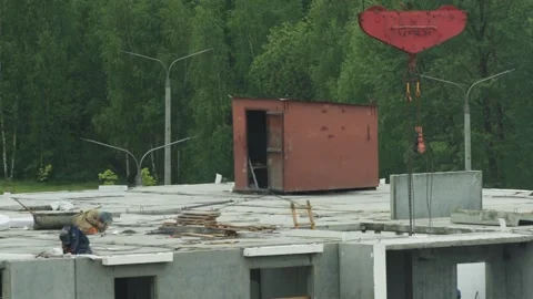Worker welding on concrete roof of panel house construction site with red crane Stock Footage 342922244