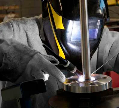 Worker welding a flanged well (thermocouple) Stock Photos