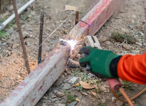 Worker welding formwork for pour concrete on road. Stock Photos