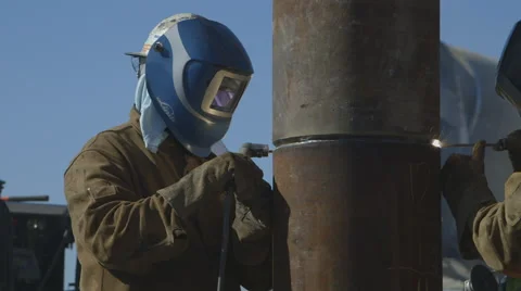 Worker welding a foundation pile while a concrete truck passes behind him Stock Footage 65051587
