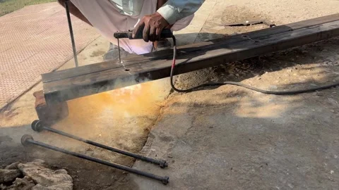 Worker Welding an Iron Pipe Using Electric Arc Welding in a Construction Site Stock Footage 324008413