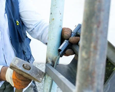 Worker welding metal elements on site Foto stock