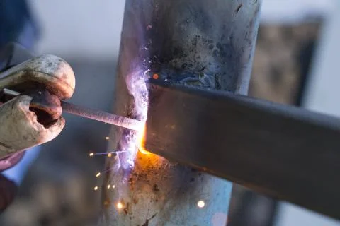 Worker welding metal elements on site Stock Photos